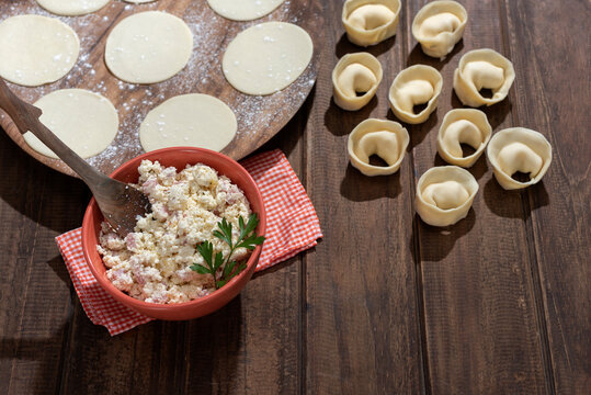 capeletinis and fresh raw homemade stuffed pasta with repulgue on wooden table and flour with tapas on plate and filling