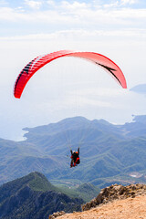 Paragliding in the sky. Paraglider tandem flying over the sea and mountains. Extreme sport