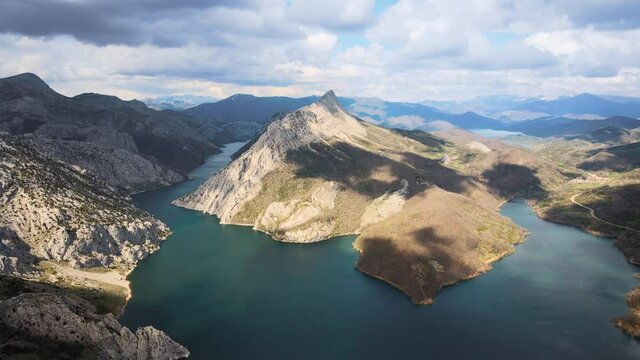 Aerial view of a beautiful landscape of mountain lake. Emerald water surrounded by mountains and passing clouds. . High quality 4k footage