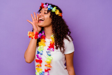Naklejka premium Young Hawaiian woman isolated on purple background shouting and holding palm near opened mouth.
