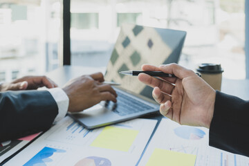 businesswomen and businessmen team meeting to plan strategies to increase business income. Have a brainstorming finance graph analysis and discussing for the new target success