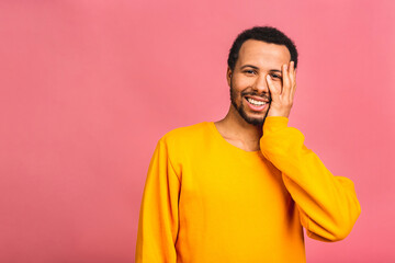 A young happy smiling funny black African American man isolated over pink background.