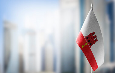 A small flag of Gibraltar on the background of a blurred background