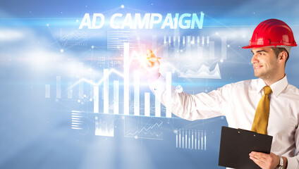 Young businessman with helmet drawing on virutal screen