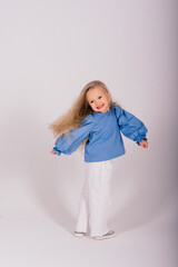 Portrait of a cheerful girl jumping and dancing against a studio background