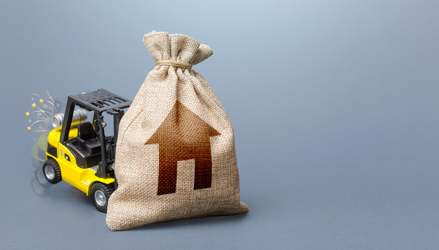 Forklift truck cannot lift the bag with house symbol. Concept of inability to maintain housing. Repair and renovation, lack of resources. Difficulty paying utility bills. Insufficient funding