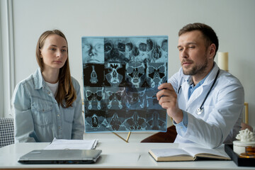 Man doctor show x-ray result and explain of health problem to women patient in his office
