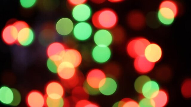 Defocused colorful christmas tree lights twinkle on black background
