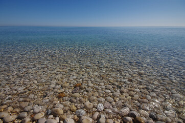 The seabed of pebbles seen through clean and transparent water.