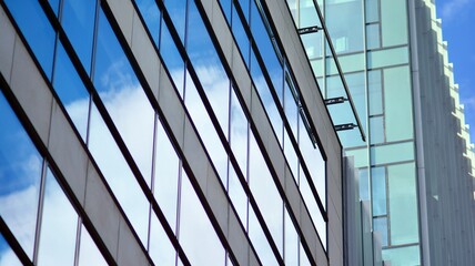 Modern office building detail, glass surface on a clear sky background. Transparent glass wall of office building.  