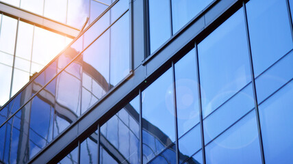 Modern office building detail, glass surface on a clear sky background. Transparent glass wall of office building.  