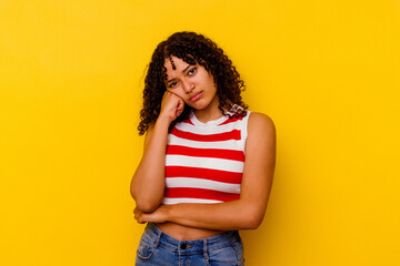 Young mixed race woman isolated on yellow background tired of a repetitive task.