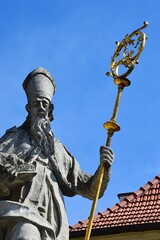 Baroque stone statue of Saint Nicholas with golden staff and a book, placed on Square of Saint...