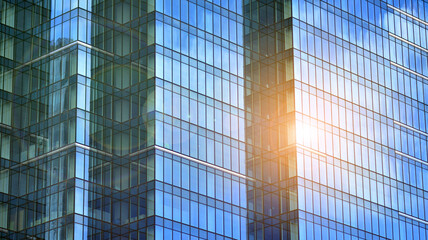 Fototapeta na wymiar Modern office building detail, glass surface on a clear sky background. Transparent glass wall of office building. 