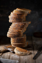 Sliced ​​white bread with poppy seeds stacked on a rustic table