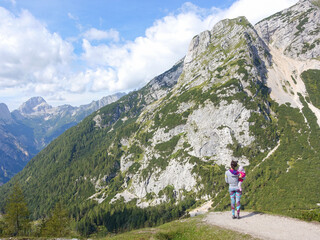 Woman with child is admiring the view of the mountains at Vrsic mountain pass in Slovenia.