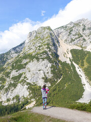Fototapeta premium Woman with child is admiring the view of the mountains at Vrsic mountain pass in Slovenia.