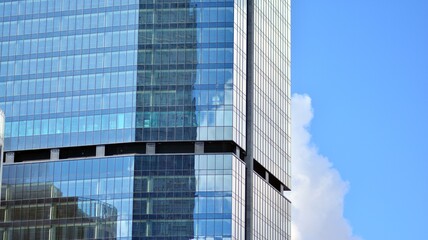 Modern office building detail, glass surface on a clear sky background. Transparent glass wall of office building.  