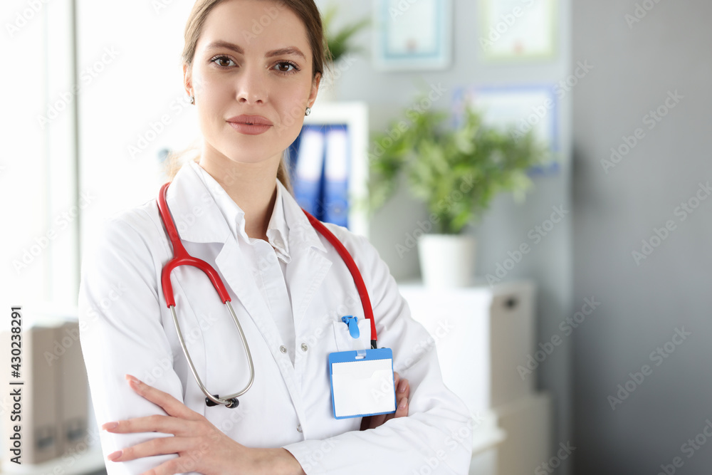 Wall mural portrait of female doctor in white coat in medical office