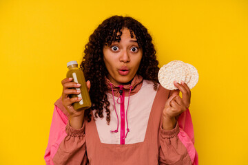 Young mixed race woman drinking a healthy drink