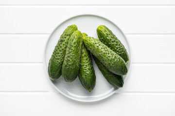 Fresh green cucumbers on white table.