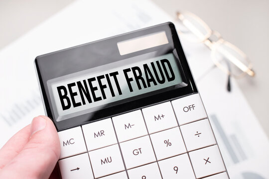 The Word Benefit Fraud Is Written On The Calculator. Business Man Holding A Calculator In His Hand.