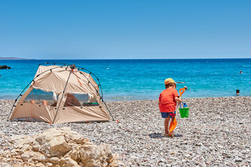 The amazing Kaladi beach, beautiful scenery with a young child, a boy playing on the beach. Ionian, Greece, Europe