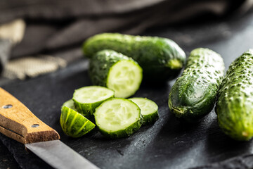 Sliced fresh green cucumbers on cutting board.