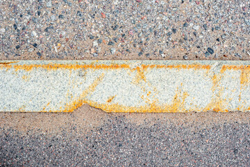 Old asphalt on the road. Horizontal curb stone on the road. City environment. Top view close up.