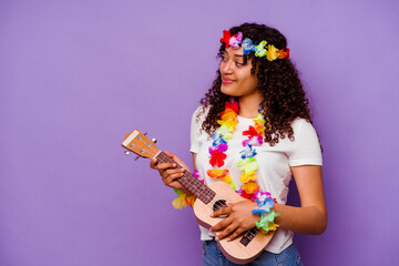 Young hawaiian woman playing ukelele isolated on purple background