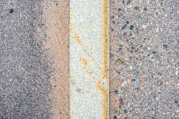 Old asphalt on the road. Vertical curb stone on the road. City environment. Top view close up.