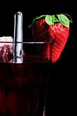 Tea with strawberry and glass on dark background.