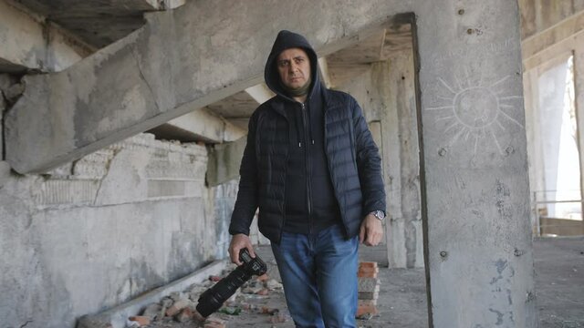A private detective or spy with a camera in an abandoned building.