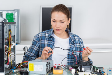 female computer technician using multimeter