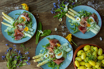 seasonal dinner with asparagus, prosciutto and young potatoes on a plate, Frankfurt green sauce,...