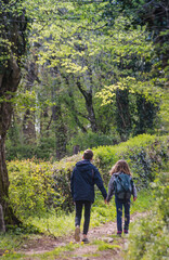 Une petite soeur et son grand frère se tiennent par la main lors d'une ballade sur un chemin en...