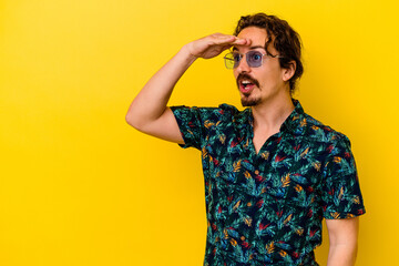 Fototapeta premium Young caucasian man wearing summer clothes isolated on yellow background looking far away keeping hand on forehead.