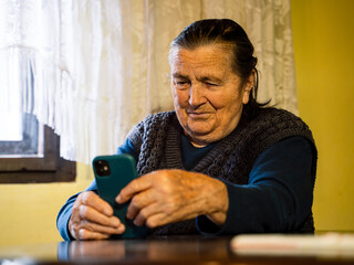 Fototapeta premium close up portrait of 90 years old woman using mobile phone 