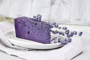 Piece of lavender cheese with dry basil and lavender flowers