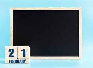 February 21. Day 21 of month, Cube calendar with date, empty frame on light blue background. Place for your text. Winter month, day of the year concept