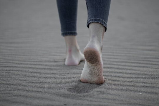 Pies bonitos des de atr&aacute;s, andando por la playa.