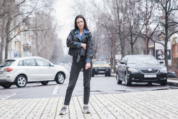 Portrait of a beautiful brunette girl who poses while walking on the street