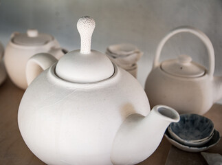 White plates of prcelan. White kettle. Gray plates..