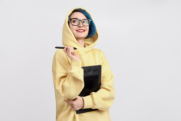 A female designer in yellow hoody holding graphic tablet