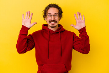 Young caucasian man isolated on yellow background receiving a pleasant surprise, excited and raising hands.