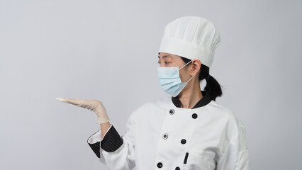 Chef wearing face protective medical mask or respirator for protection from virus disease. Food safety and coronavirus pandemic. chef posing gesture represent online ordering. food healthcare.