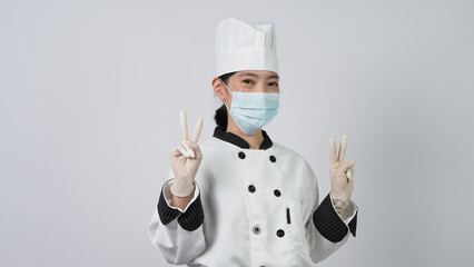 Chef wearing face protective medical mask or respirator for protection from virus disease. Food safety and coronavirus pandemic. chef posing gesture represent online ordering. food healthcare.
