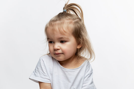 Pensive little girl 2 years old. White background.