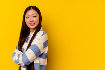 Young chinese woman isolated on yellow background smiling confident with crossed arms.