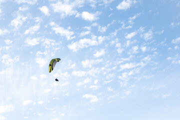 person flying on paraglider with blue sky in the background